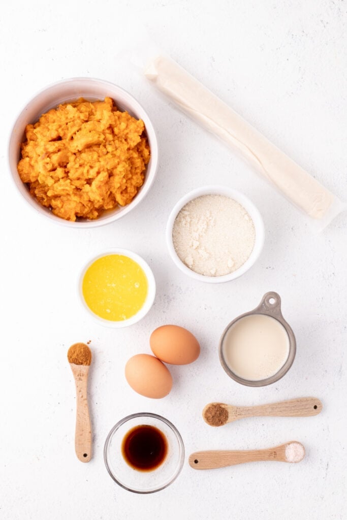 Mixing bowl filled with mashed sweet potatoes, melted butter, eggs, and spices before blending for sweet potato pie filling.