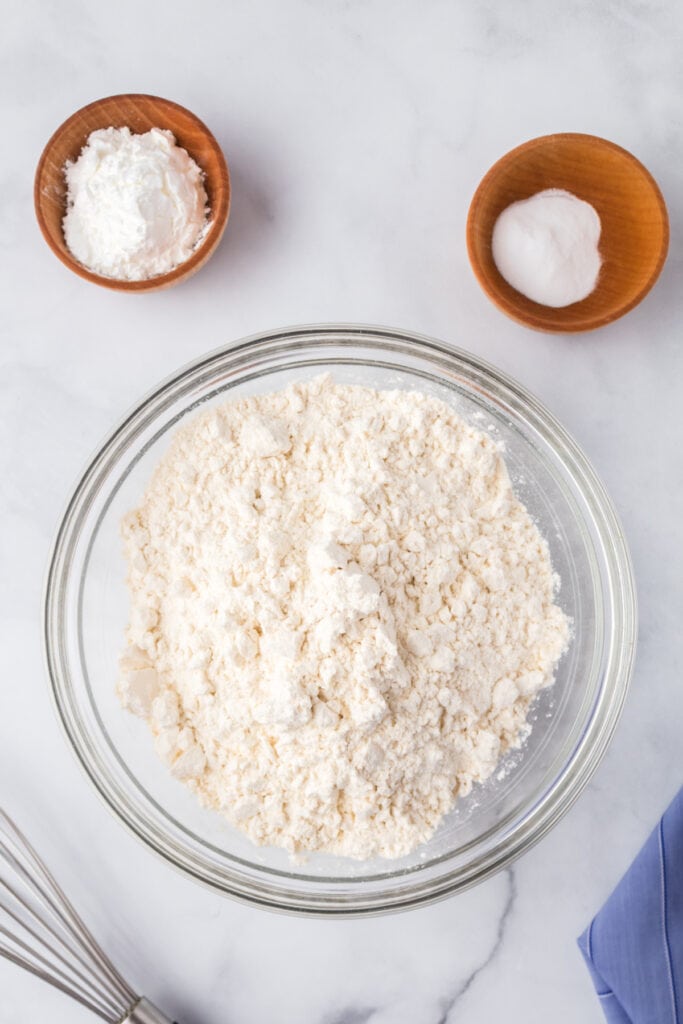 Dry ingredients including flour, cornstarch, and baking soda combined in a glass bowl ready to mix into Butter Pecan Cookies dough.