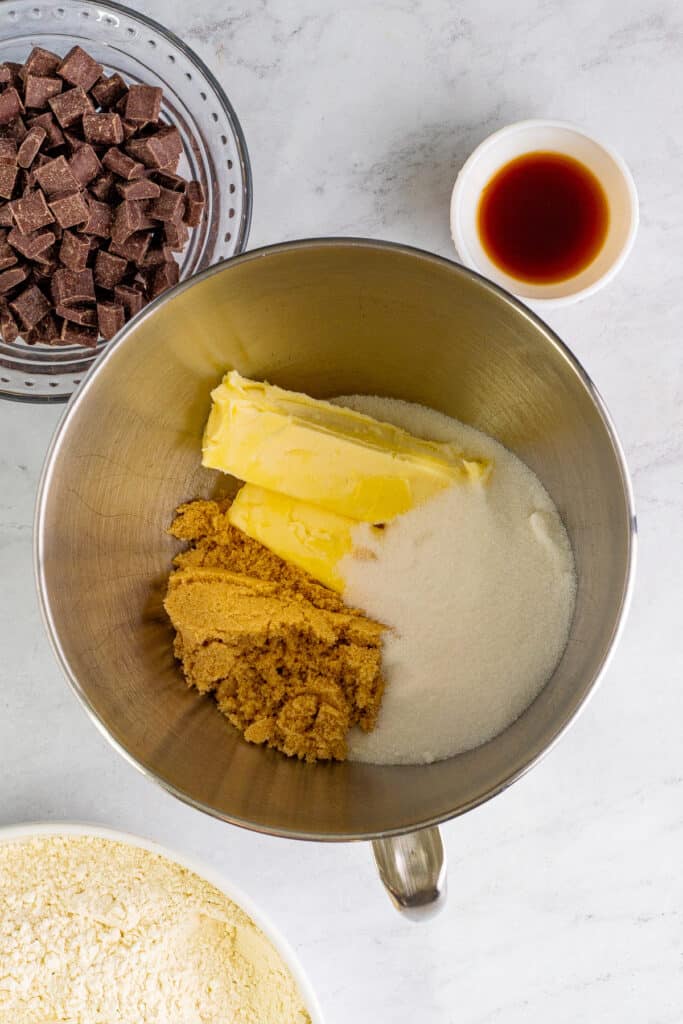 Butter, brown sugar, and granulated sugar in a mixing bowl ready to be creamed together.