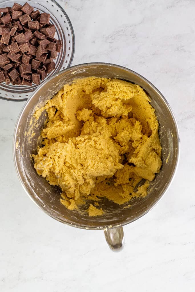 Thick cookie dough mixed together in the bowl with a light golden color.