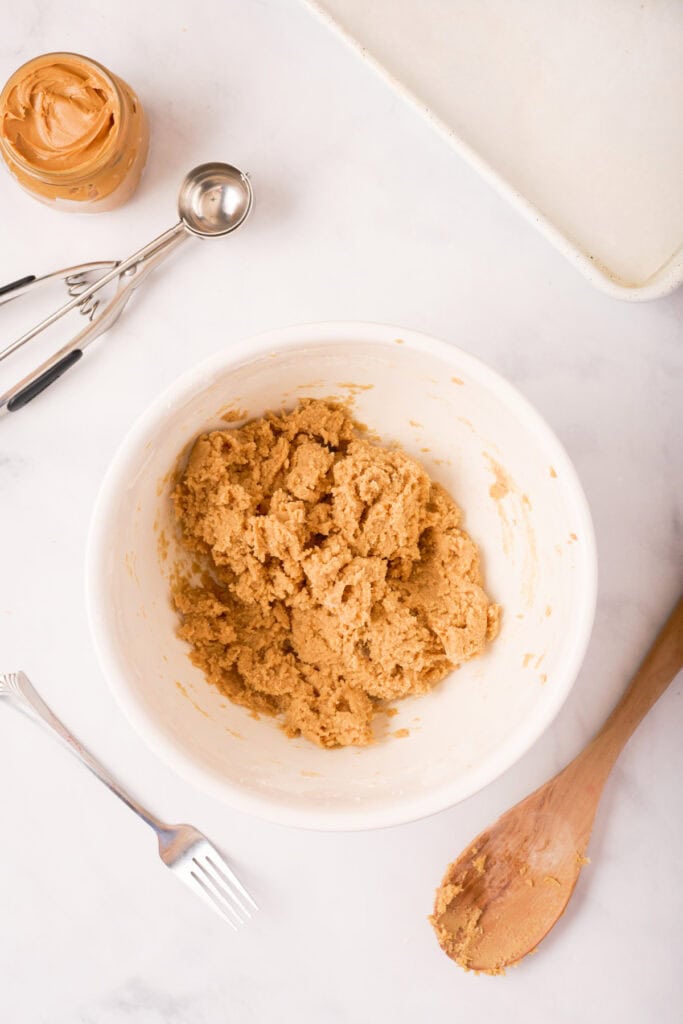 Mixed peanut butter cookie dough after combining dry ingredients, thick and soft, ready for shaping.