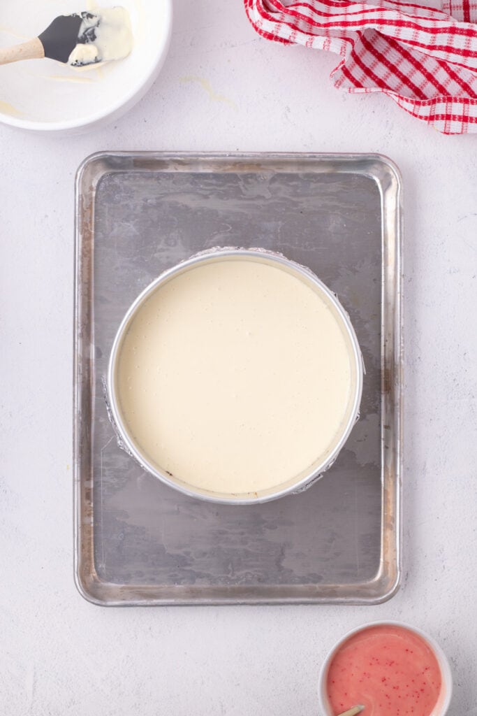 Cheesecake batter poured into the springform pan over the crust, ready for the peppermint swirl.