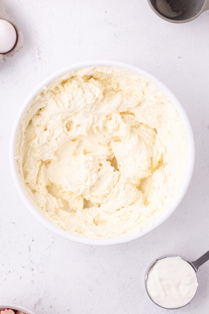 Whipped cream cheese and sugar mixture in a white bowl, beaten until smooth and fluffy.