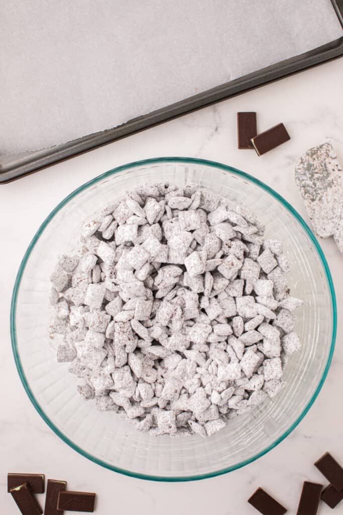 Fully coated Thin Mint Muddy Buddies in a large bowl before spreading on a baking sheet.