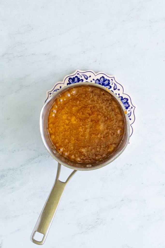 melted butter and brown sugar mixture bubbling in a saucepan as it begins to turn into caramel