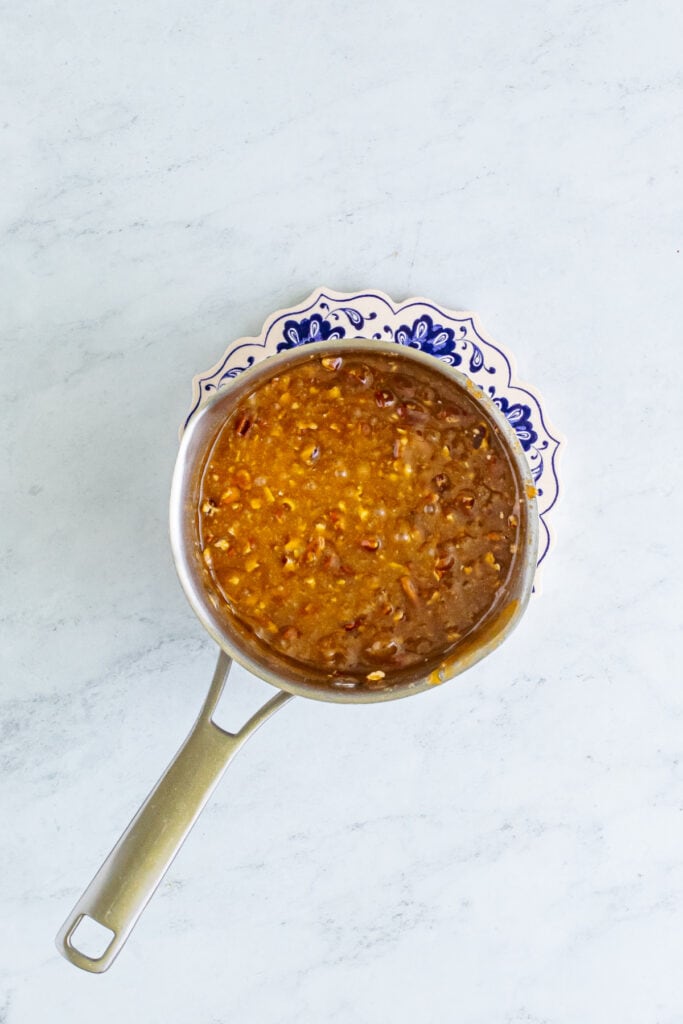 saucepan of boiling caramel with chopped pecans stirred in