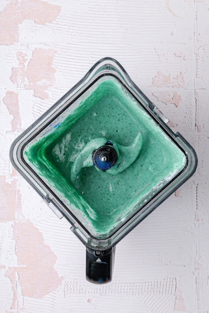 Blended blue spirulina smoothie inside a blender jar, showing a smooth and creamy texture before serving.