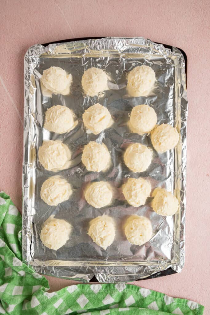 buttercream balls arranged on a foil lined baking sheet before chilling