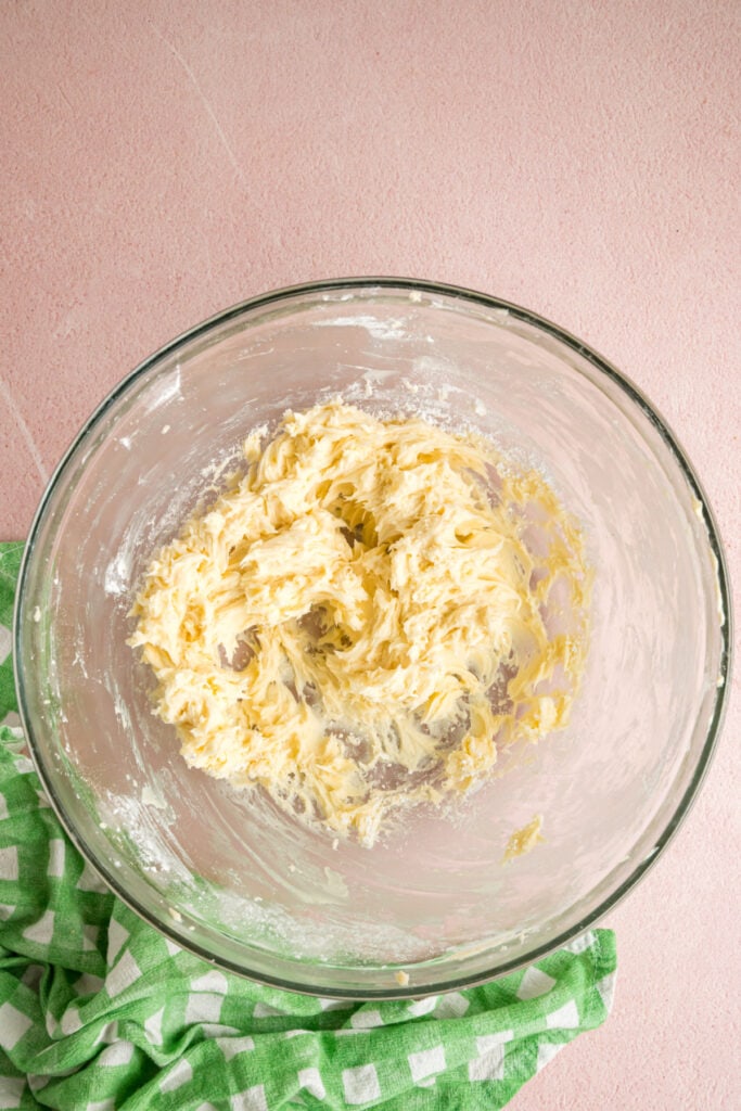 butter and powdered sugar partially mixed together in a glass bowl