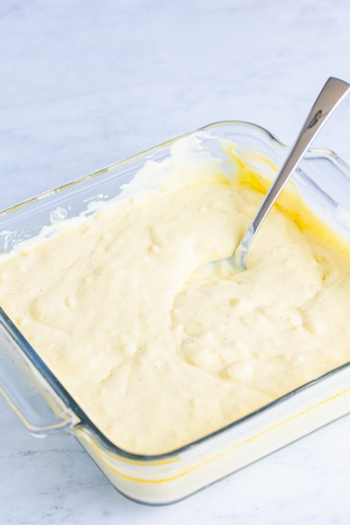 chilled creme brulee custard being stirred until smooth in a glass baking dish