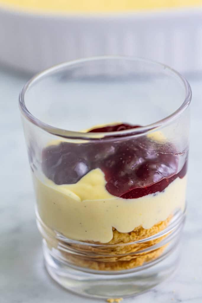 raspberry jam layered over vanilla custard in a clear dessert glass
