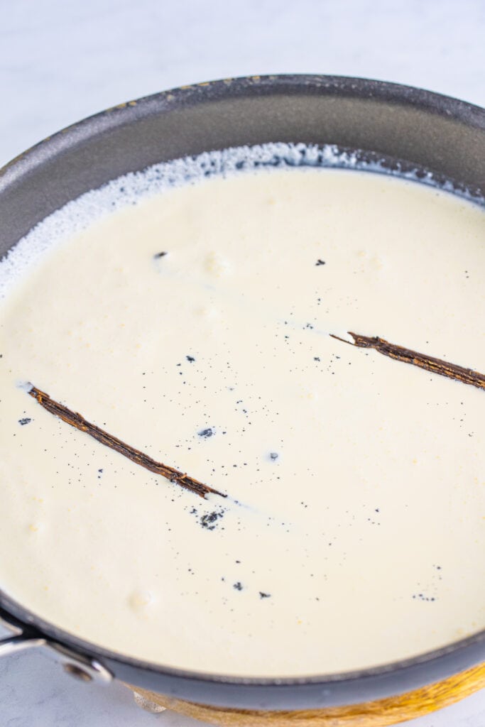 vanilla bean pods steeping in warm cream for creme brulee custard