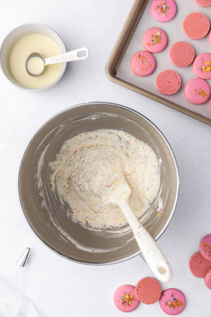 fruity pebbles buttercream fully mixed in a stand mixer bowl