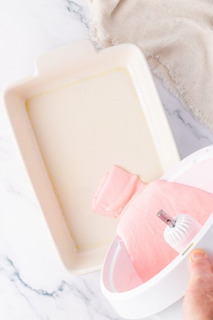 pouring cake batter mixture into a rectangle baking dish