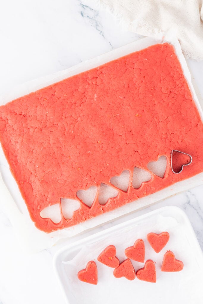 Heart-shaped strawberry cake truffles cut from the pressed cake mixture