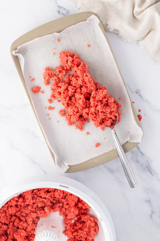 Strawberry cake crumbs mixed with frosting until fully combined