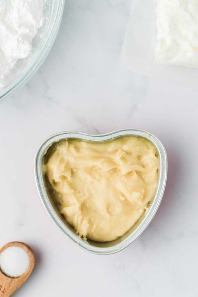 Cake batter poured into a heart shaped baking pan before baking