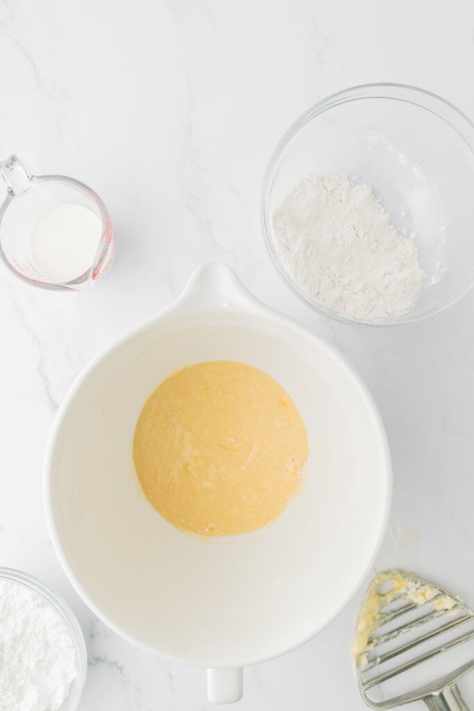 Cake batter mixed until smooth and pale yellow in a white mixing bowl