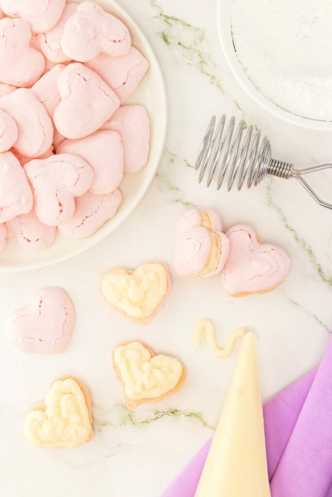 filling Valentine macarons with vanilla buttercream using a piping bag