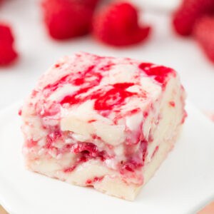 Close-up of a single square of white chocolate raspberry fudge with smooth white chocolate and raspberry streaks