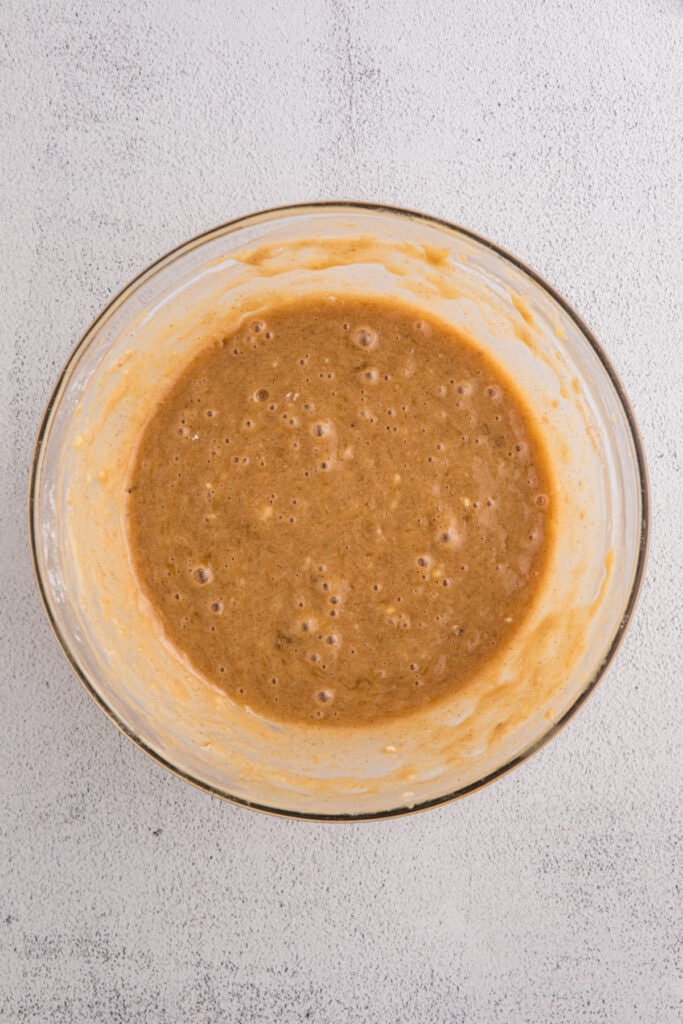 Glass bowl with fully mixed banana brownie batter
