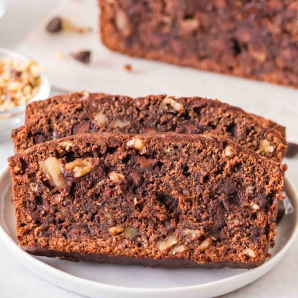 Square image of sliced brownie banana bread showing chocolate chips and walnuts in the crumb.
