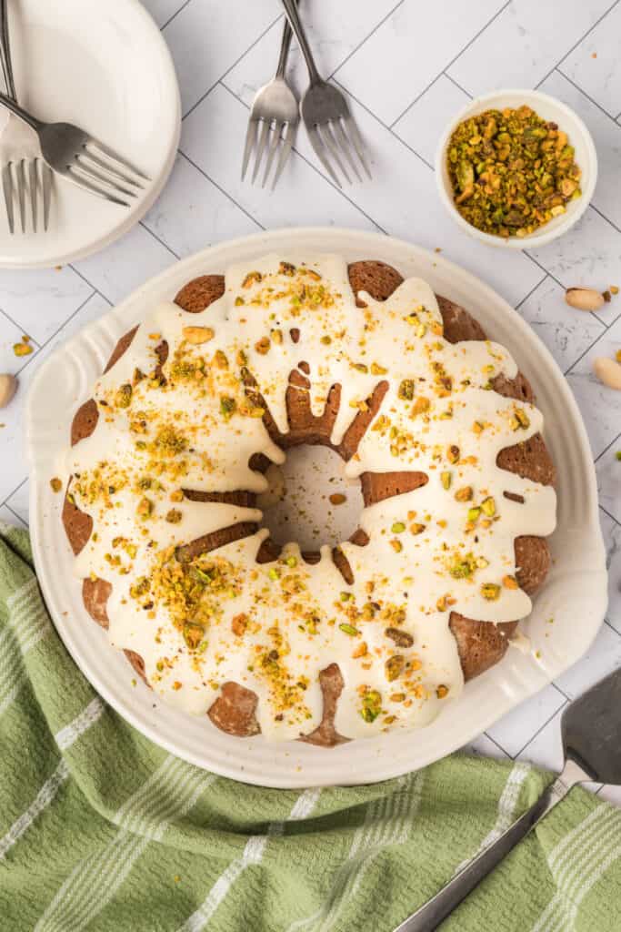 pistachio bundt cake topped with glaze and chopped pistachios