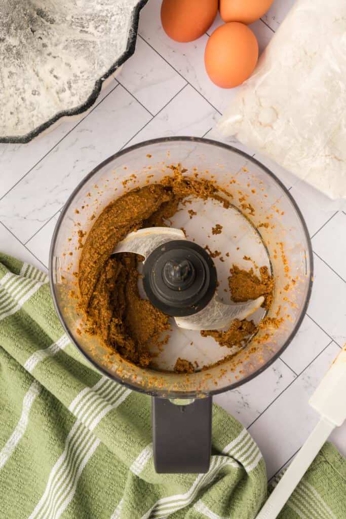 blended pistachios forming a thick paste inside a food processor