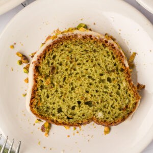 square image of a slice of pistachio bundt cake on a plate
