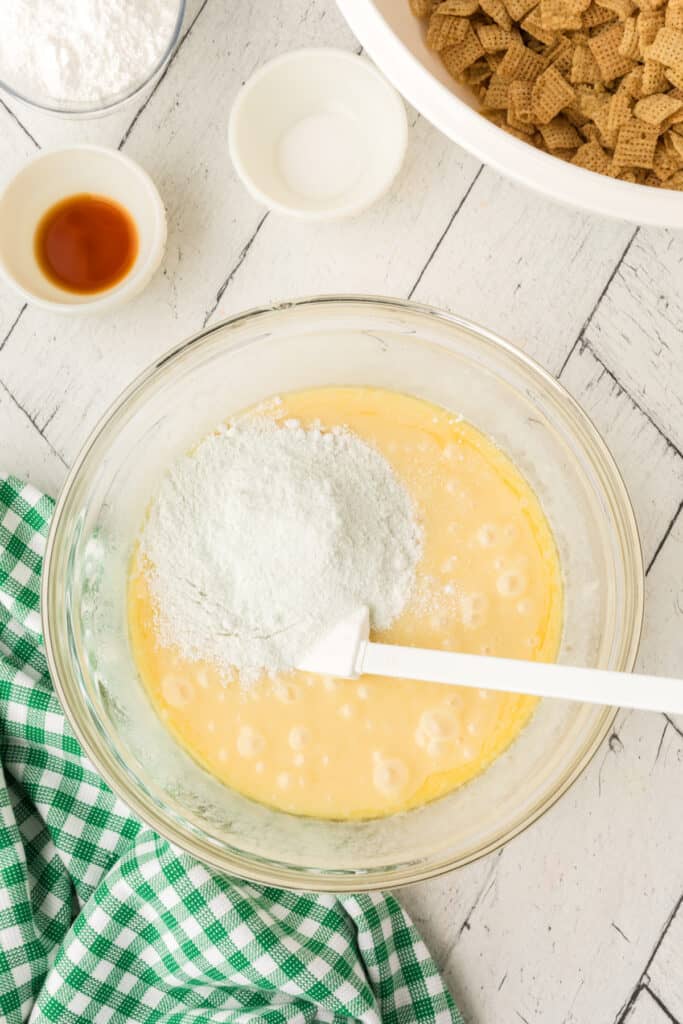Glass bowl with pistachio pudding mix added to melted mixture before stirring