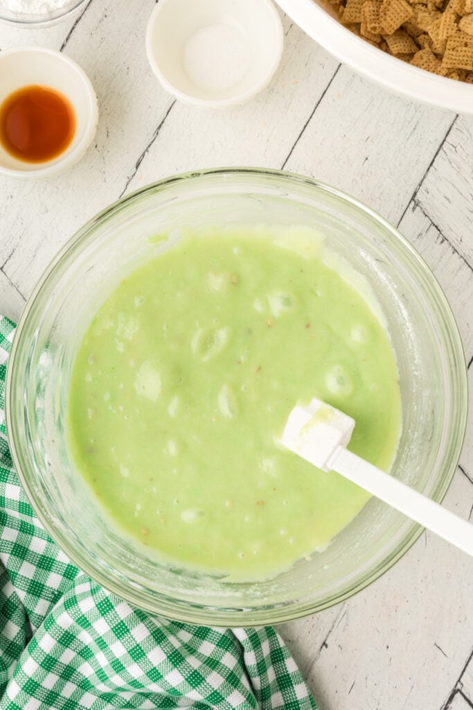 Glass bowl with green pistachio mixture fully combined and smooth with spatula inside