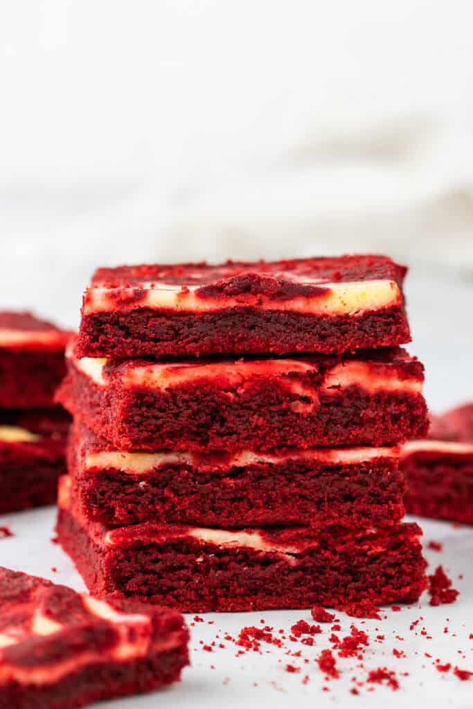 Stack of red velvet cheesecake brownies showing layers of red velvet and cream cheese