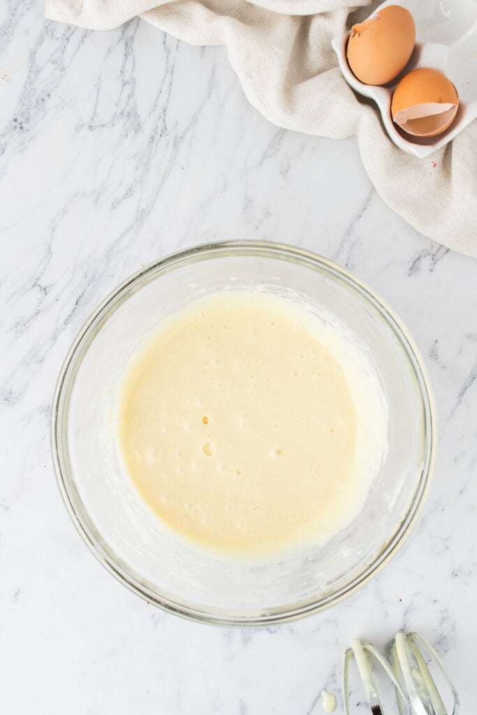 Smooth cream cheese mixture in a glass bowl after mixing