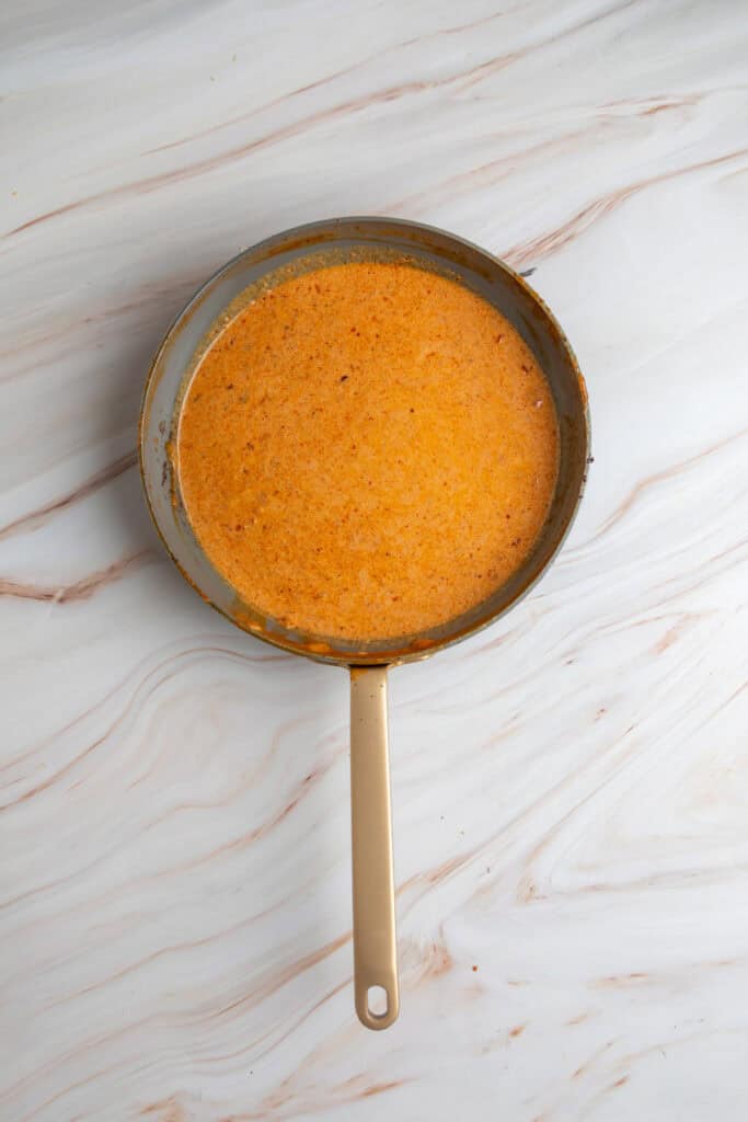 overhead view of a skillet filled with orange coconut curry sauce