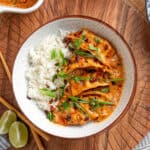 plated baked curry dumplings with rice topped with green onions, cilantro, and chili crunch