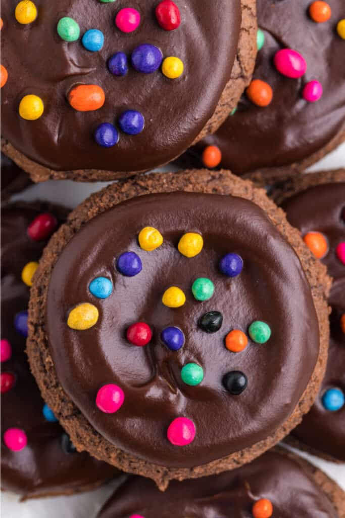 close up of a chocolate cookie with glossy ganache and rainbow candy-coated chips