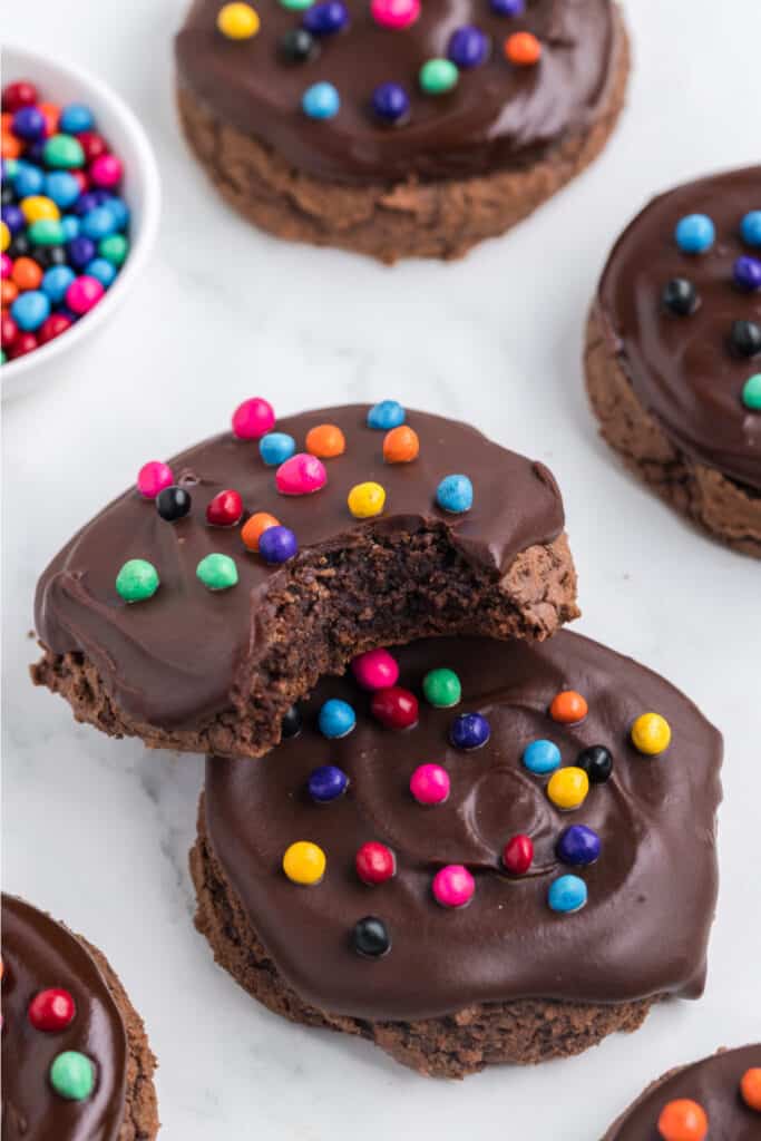 chocolate cookie with a bite taken out showing fudgy center and ganache topping