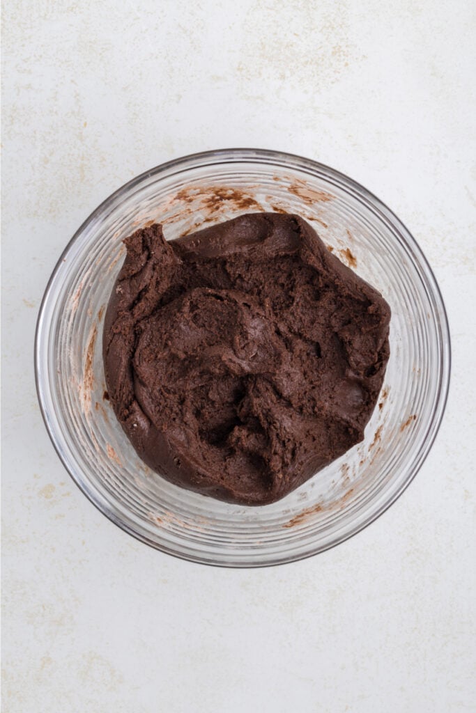 thick chocolate cookie dough in a glass mixing bowl