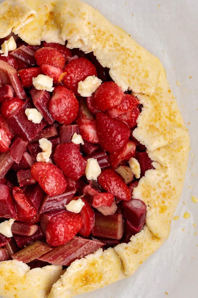 close-up of galette crust sprinkled with sugar and filled with strawberries and rhubarb