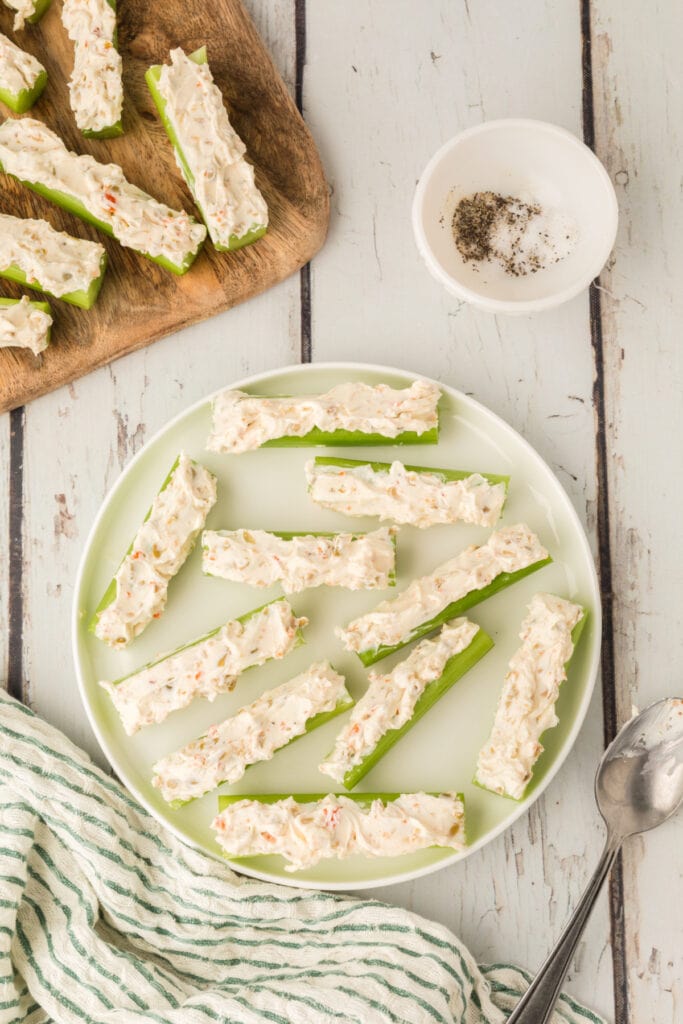 celery sticks filled with cream cheese mixture arranged on a plate