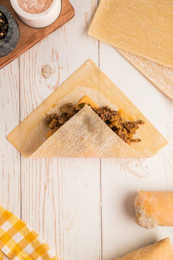 egg roll wrapper folded with slurry brushed on edges for sealing Big Mac Egg Rolls