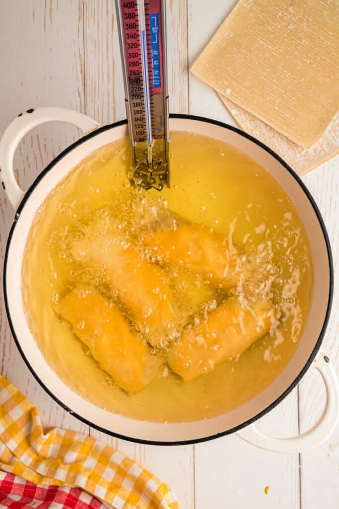Big Mac Egg Rolls frying in hot oil with thermometer showing temperature