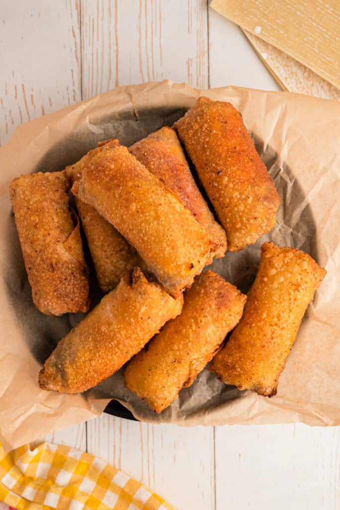 crispy fried Big Mac Egg Rolls resting on parchment-lined plate