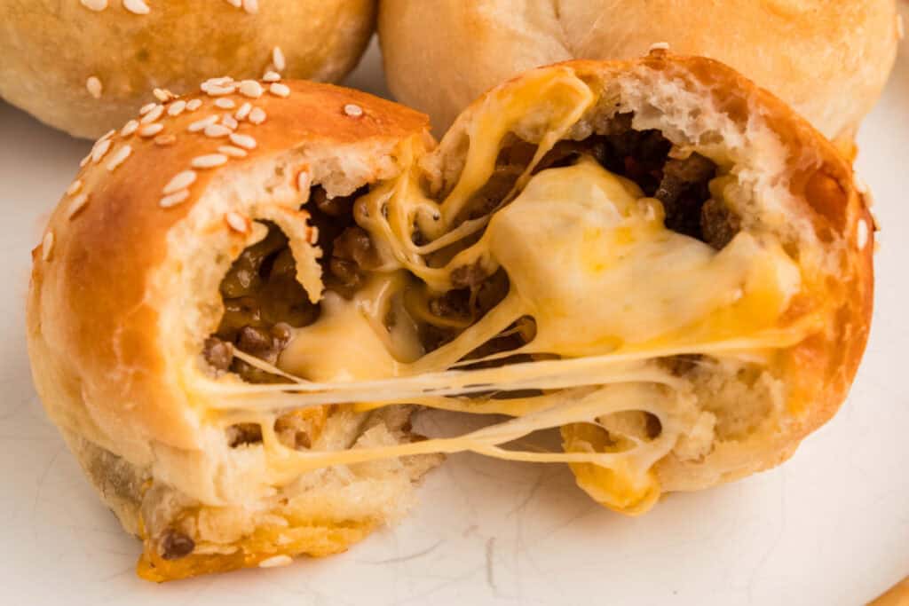 burger bomb pulled apart showing melted cheese stretching between the halves