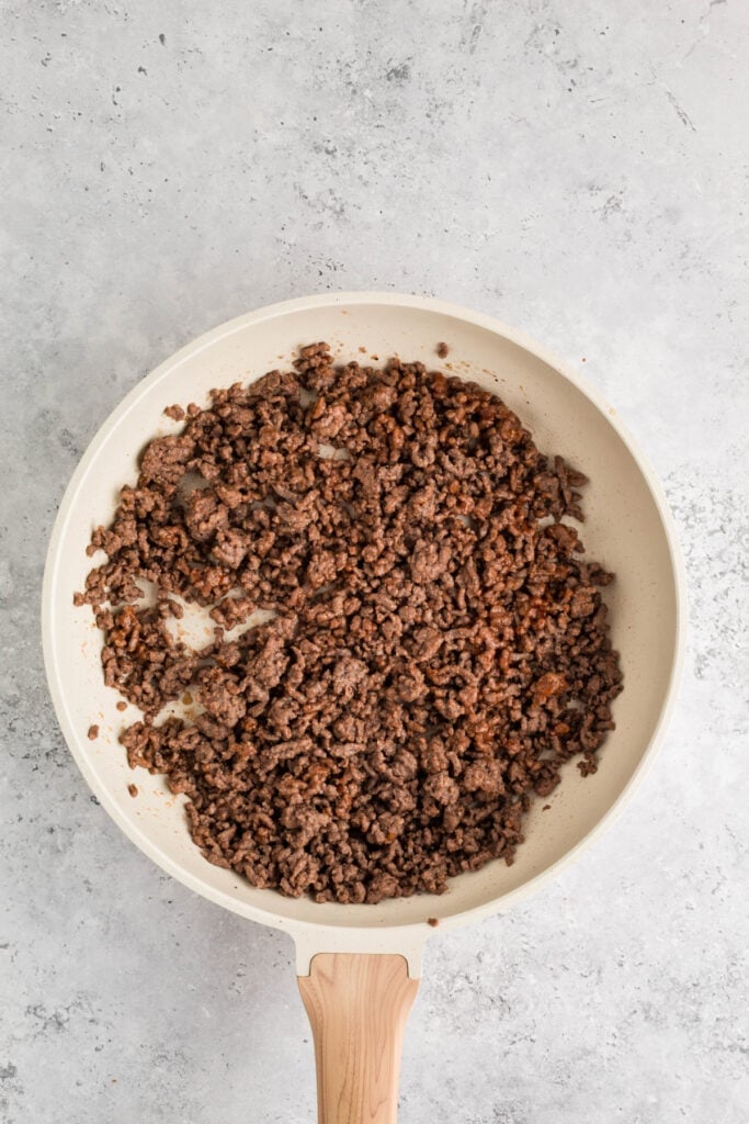 cooked ground beef mixed with ketchup in a skillet