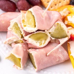 close-up of Ham And Pickle Roll-Ups stacked with visible pickle centers and cream cheese filling