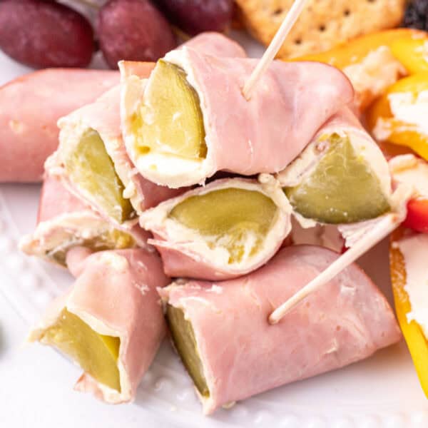 close-up of Ham And Pickle Roll-Ups stacked with visible pickle centers and cream cheese filling