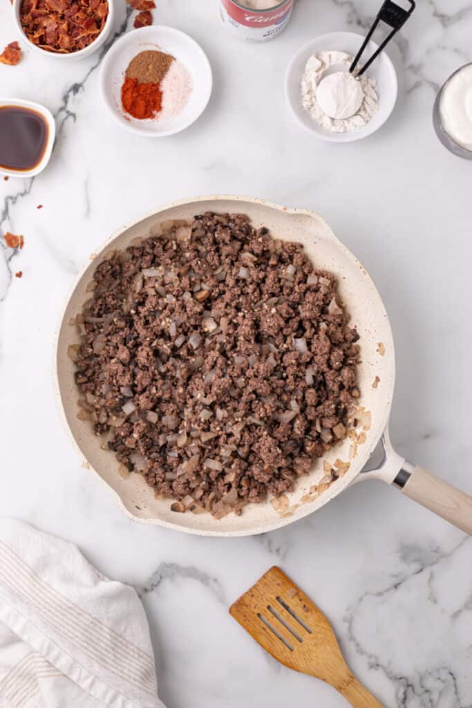 cooked ground beef with softened onions and mushrooms in a skillet for hamburger stroganoff sloppy joes