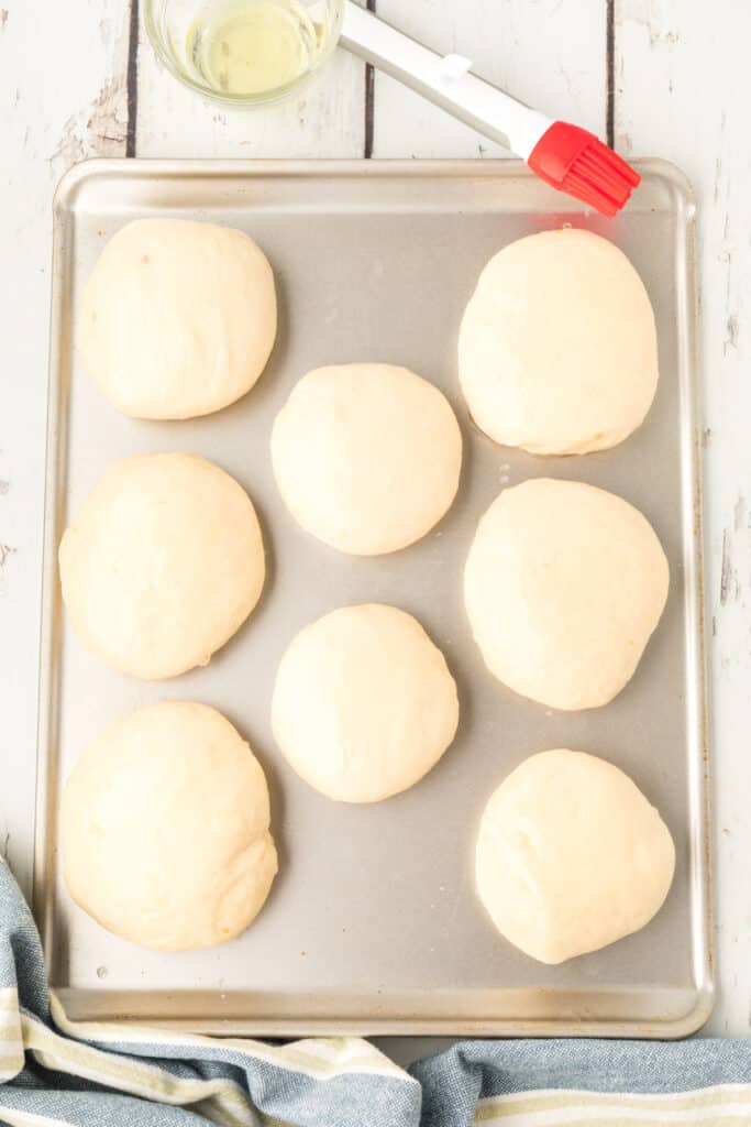 homemade onion rolls dough brushed with egg wash on a baking sheet before baking
