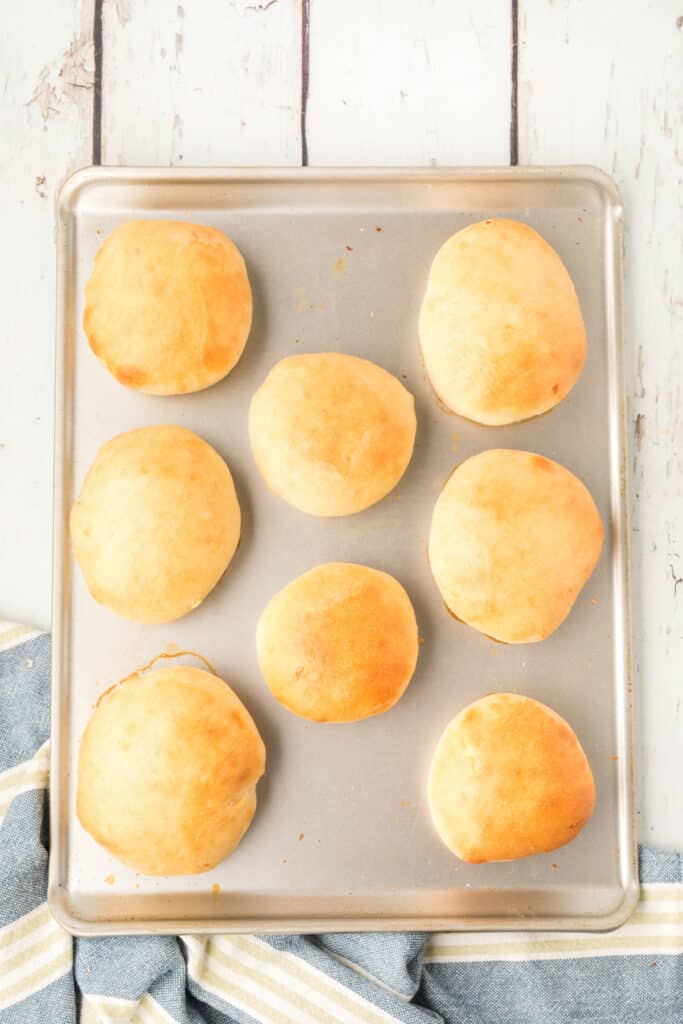 baked homemade onion rolls on a baking sheet with golden brown tops